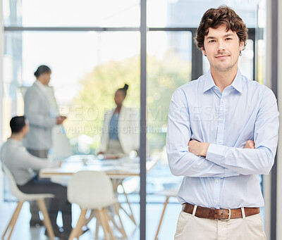 Buy stock photo Shot of a young businessman standing in an office at work