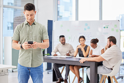 Buy stock photo Man, phone and texting in boardroom with colleagues, workshop and networking for deal at startup. Business people, employee or person with smartphone, reading and typing for chat on social media app