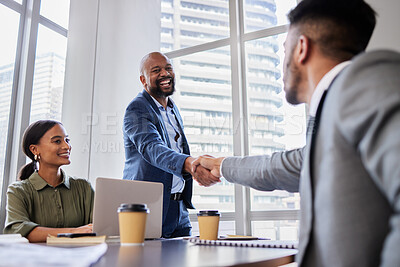 Buy stock photo Shot of two business people shaking hands during a meeting