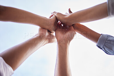 Buy stock photo Low angle shot of an unrecognisable group of businesspeople standing together and giving each other a high five