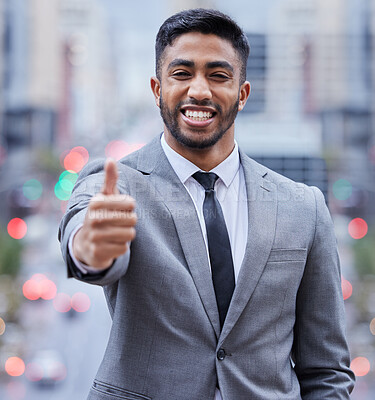 Buy stock photo Shot of a handsome young businessman standing alone and showing a thumbs up