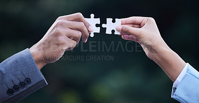 Buy stock photo Cropped shot of two unrecognisable businesspeople standing together and holding puzzle pieces