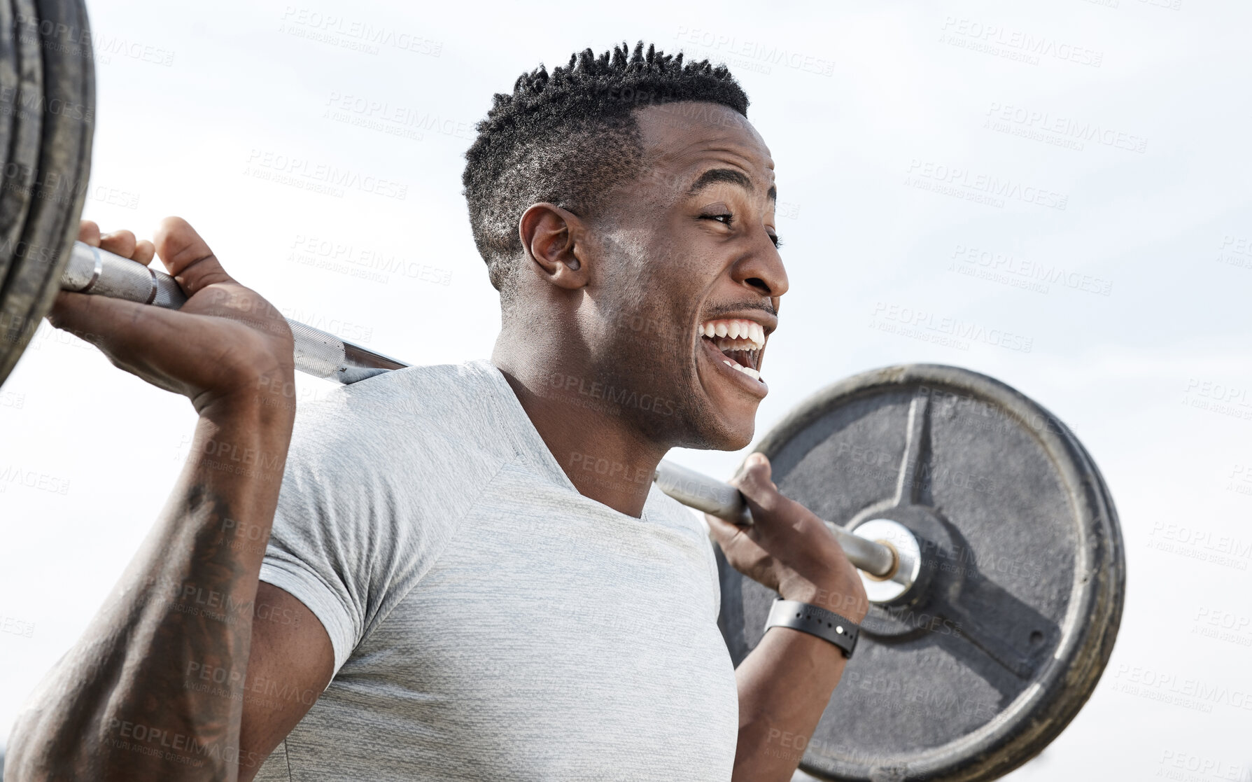 Buy stock photo Shot of a man using a barbell while exercising outdoors