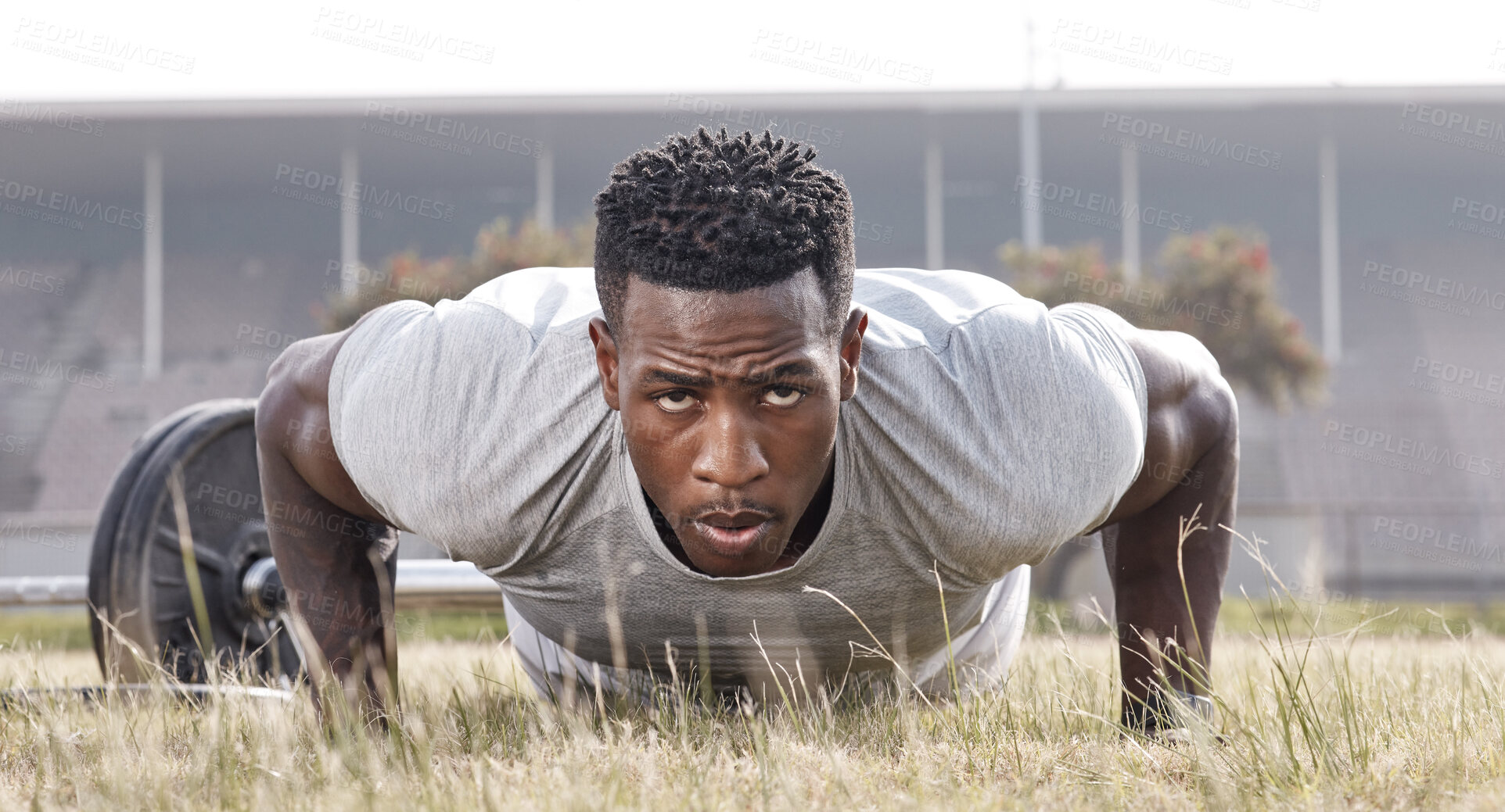 Buy stock photo Shot of a masculine man doing push-ups outside