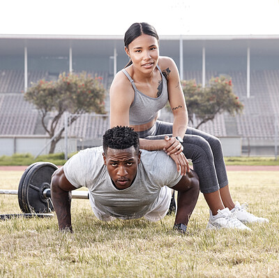 Buy stock photo Shot of a young woman sitting on a man's back while he does push-ups