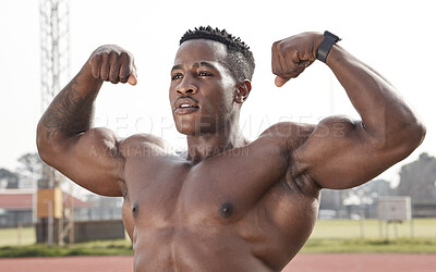 Buy stock photo Shot of a masculine young man flexing while standing outside