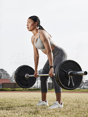 Buy stock photo Shot of a young woman using a barbell while exercising outdoors