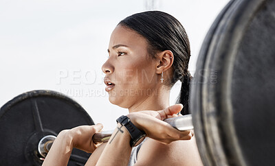 Buy stock photo Shot of a young woman using a barbell while exercising outdoors