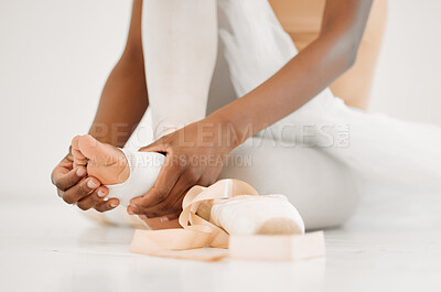 Buy stock photo Shot of an unrecognizable ballet dancer tying on her pointe shoes