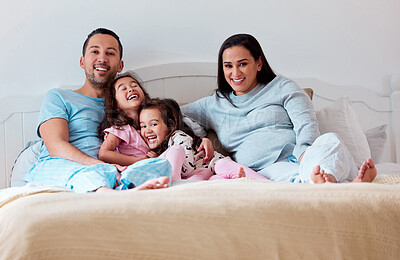 Buy stock photo Shot of a couple lying on bed with their two daughters