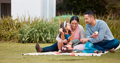 Buy stock photo Shot of a young family having a picnic in a park
