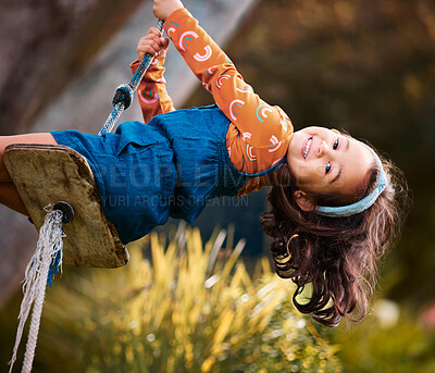Buy stock photo Shot of a little girl swinging in a park