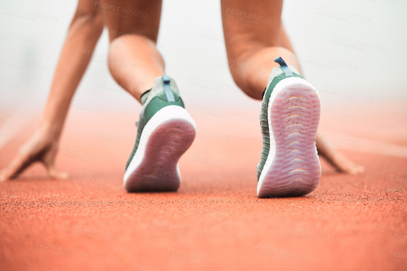 Buy stock photo Rearview shot of an unrecognizable young sportswoman taking her mark on a running track