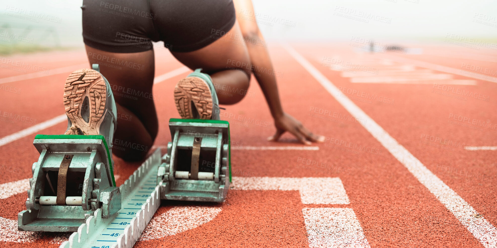 Buy stock photo Rearview shot of an unrecognizable young sportswoman taking her mark on starting blocks