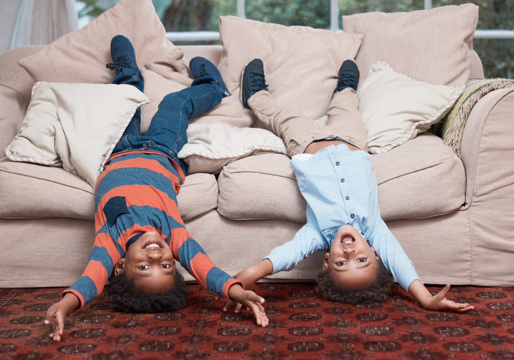 Buy stock photo Portrait of two little boys lying upside down on a sofa at home