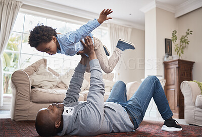 Buy stock photo Shot of a little boy having fun with his father at home