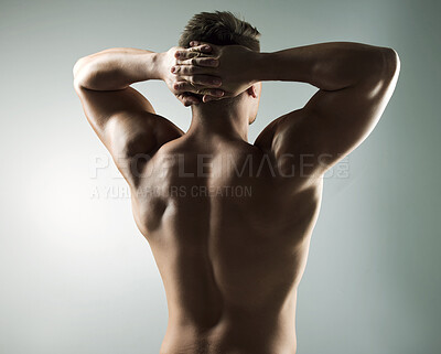Buy stock photo Studio shot of a muscular young man posing against a grey background