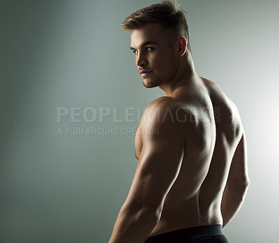Buy stock photo Studio portrait of a muscular young man posing against a grey background