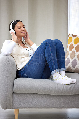 Buy stock photo Headphones, happy and woman on sofa in home for relaxing, resting and chill on weekend. Music, smile and person on couch listening to audio, song and radio on streaming subscription in living room