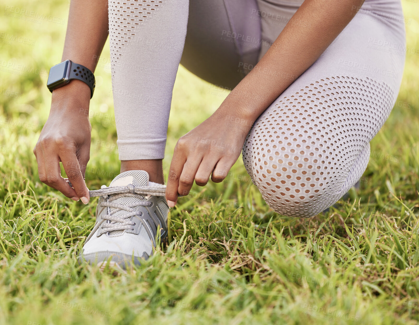 Buy stock photo Closeup shot of an unrecognisable woman tying her shoelaces while exercising outdoors