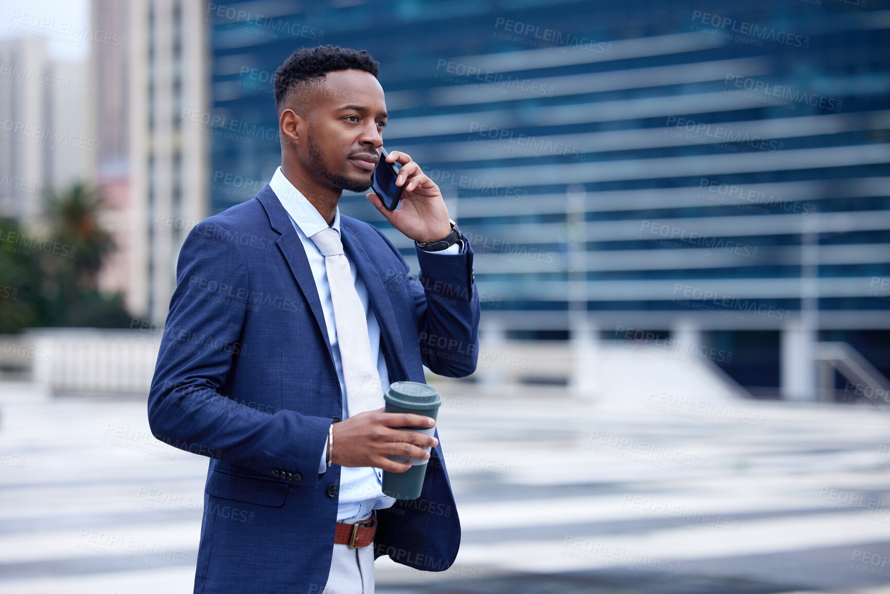 Buy stock photo Shot of a young businessman walking and using a phone in the city