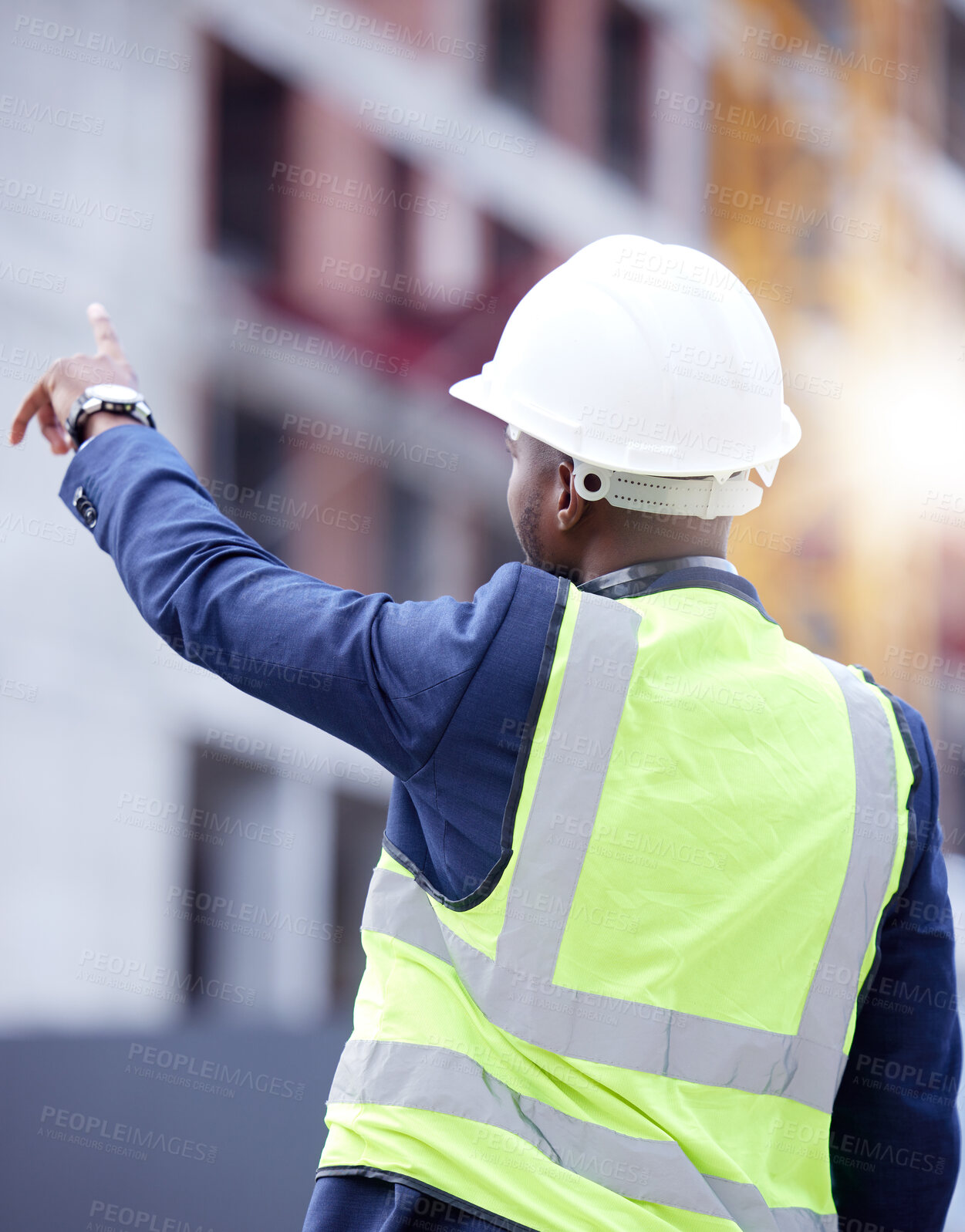 Buy stock photo Civil engineering, pointing and man on site in helmet, vest and safety inspection on urban construction. Project manager, contractor or technician from back for city maintenance, building or planning