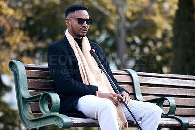 Buy stock photo Blind black man, park and sitting with sunglasses, walking stick and relax by trees, peace and thinking. African guy, vintage fashion and young person with disability, glasses and travel in nature