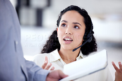 Buy stock photo Shot of a young call centre agent talking to a colleague in an office