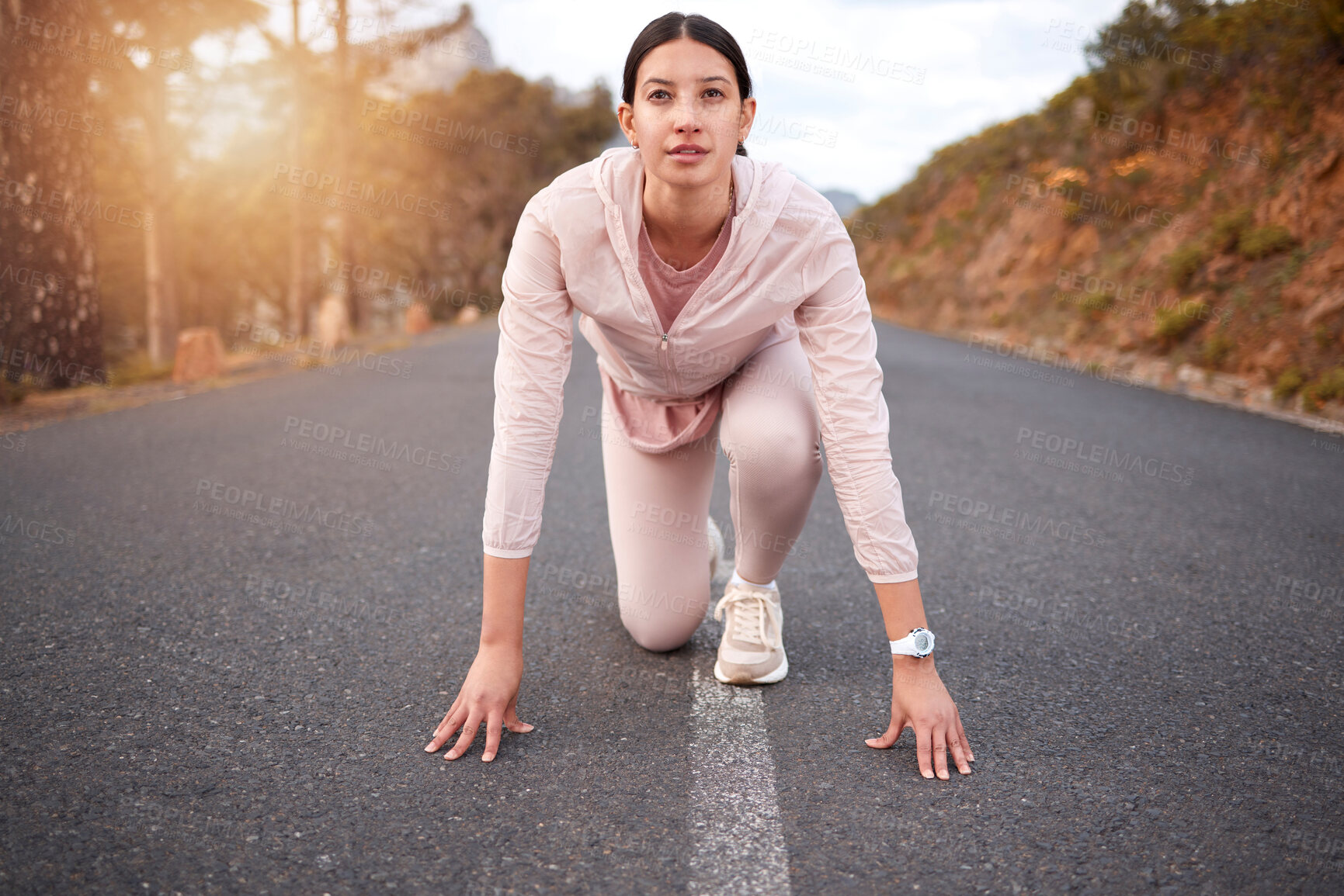 Buy stock photo Shot of a young woman in starting position while exercising outdoors