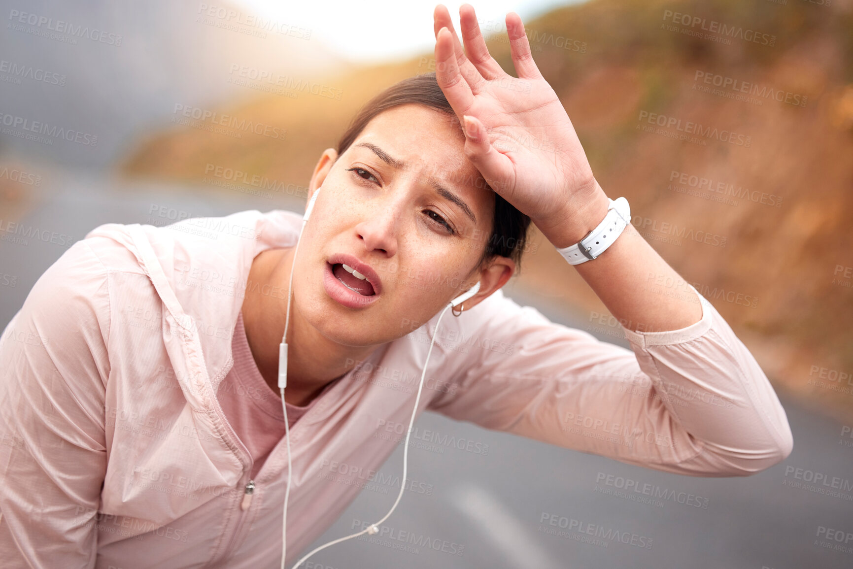 Buy stock photo Shot of a young woman taking a break while exercising outdoors