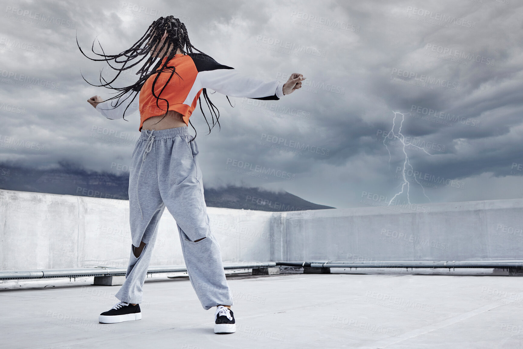 Buy stock photo Girl, dance and hip hop outdoor on city rooftop with lightning storm and cool gen z streetwear fashion. Woman, moving and dancer with creative energy on apartment balcony and urban style or freedom