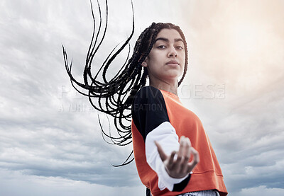 Buy stock photo Low angle portrait of an attractive young woman dancing against a stormy backdrop