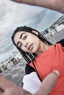 Buy stock photo Cropped portrait of an attractive young female dancer taking a selfie while standing on a rooftop against a stormy backdrop