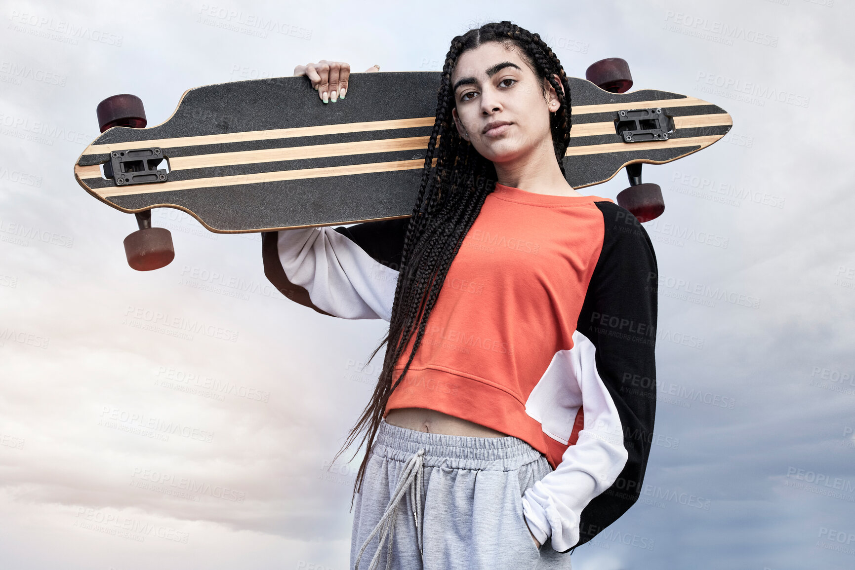 Buy stock photo Skateboard, clouds and portrait of woman with fashion for skating with casual, trendy and cool outfit. Serious, sky and female skater with confidence for hobby and street style in California.