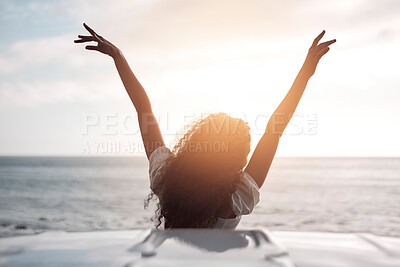 Buy stock photo Back, ocean and woman with arms raised, travel and sunshine with freedom, mindset and excited. Rear view, person and seaside with girl, summer and carefree with vacation, vehicle and getaway trip