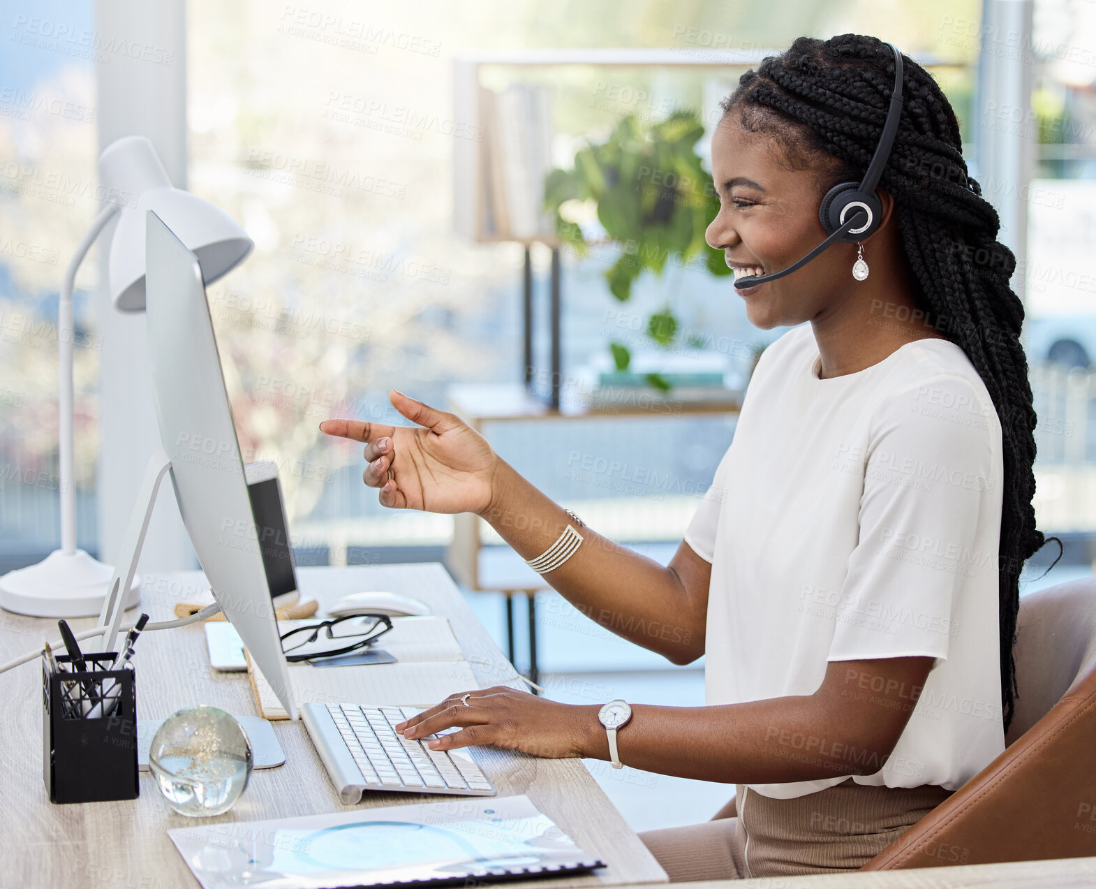 Buy stock photo Shot of a young female call center agent using a computer at work