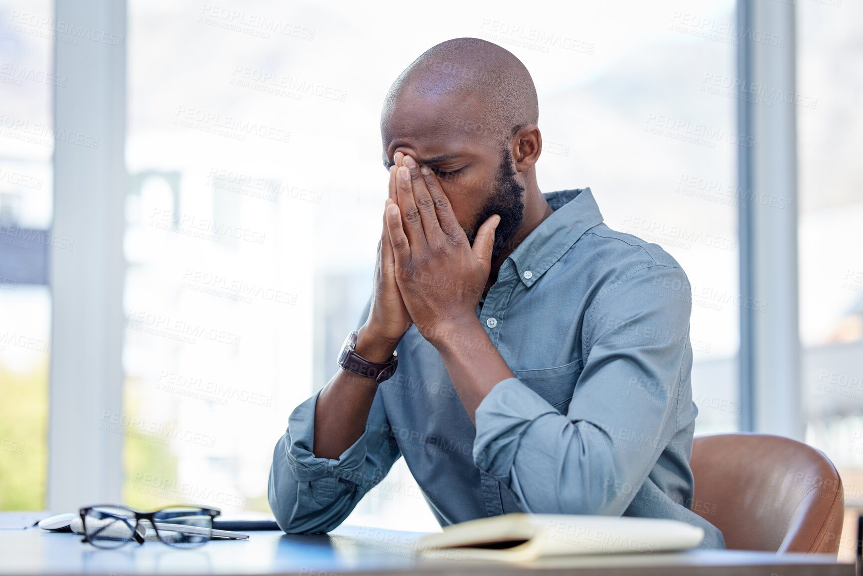 Buy stock photo Mental health, businessman with a headache and at his desk of his workplace office. Anxiety or burnout, problem or mistake and African male sitting with stress or sad at his modern workstation