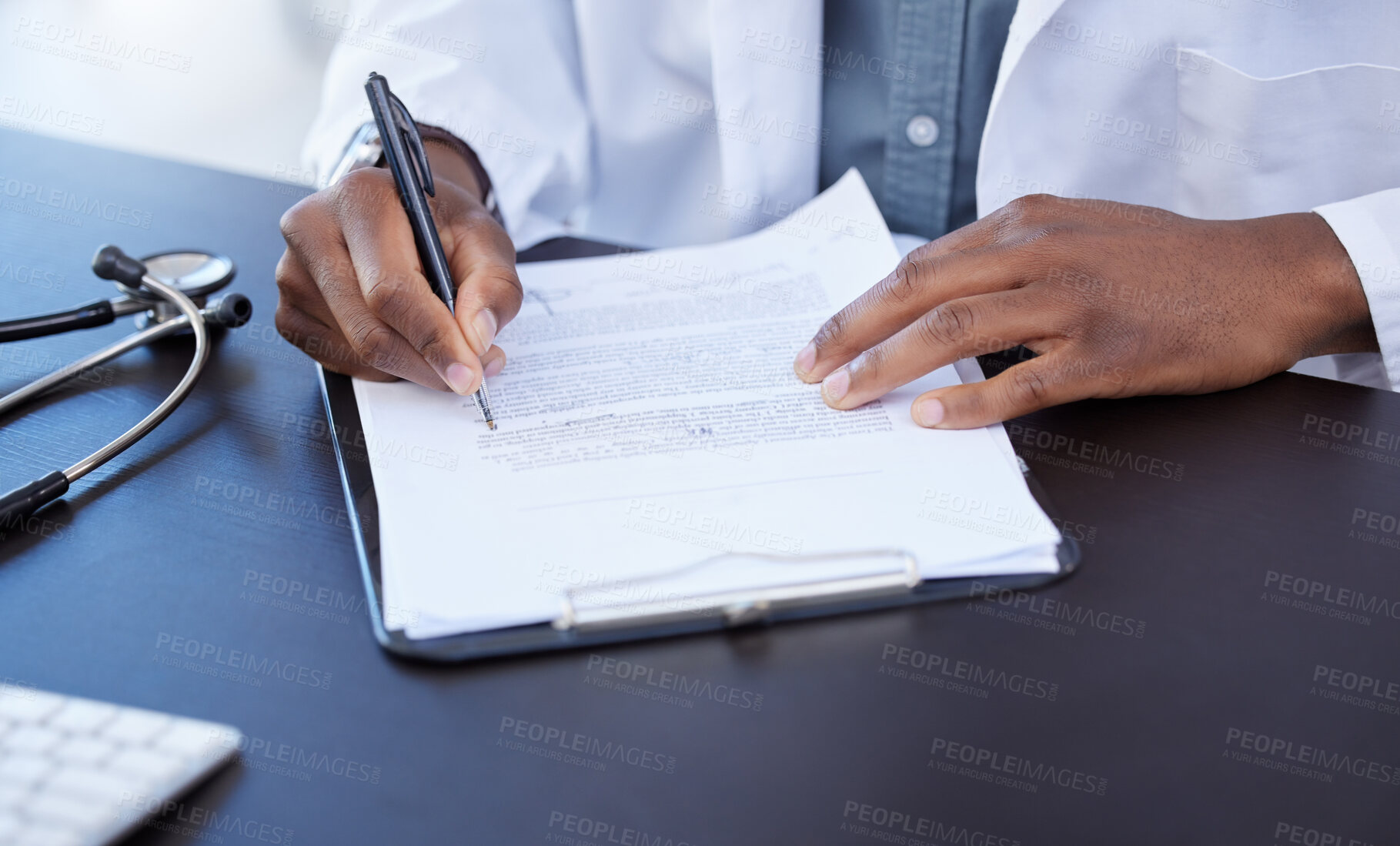 Buy stock photo Closeup shot of a male doctor filling out paperwork