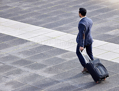 Buy stock photo Shot of a businessman making his way to the airport with his suitcase