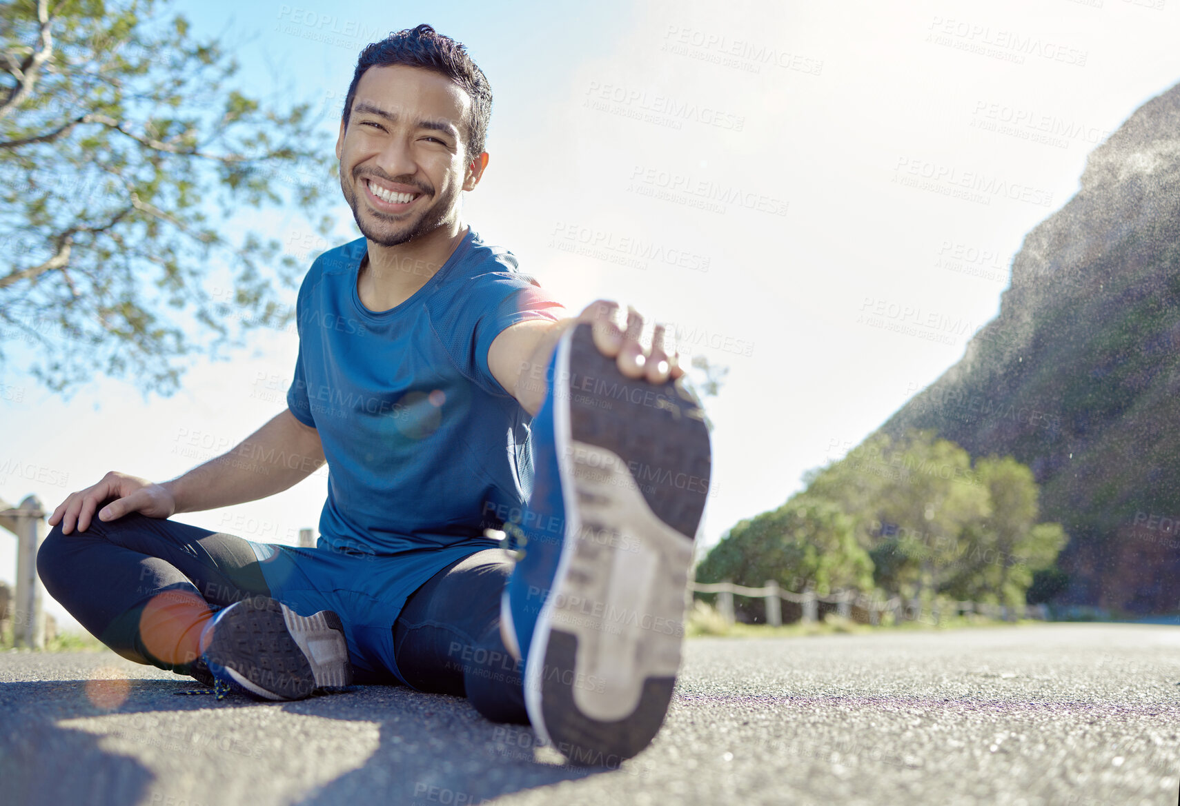 Buy stock photo Exercise, portrait and stretching with a man runner outdoor in the mountains for a cardio or endurance workout. Fitness, sports and smile with a young male athlete getting ready for a run in nature
