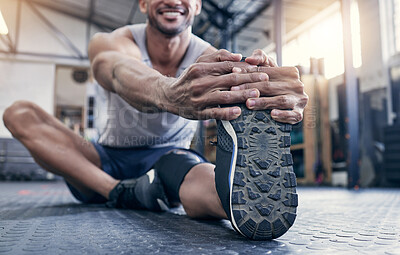 Buy stock photo Closeup shot of an unrecognisable man stretching his legs while exercising in a gym