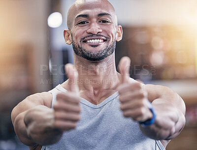 Buy stock photo Portrait of a muscular young man showing thumbs up in a gym