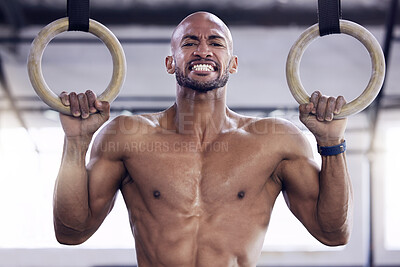 Buy stock photo Shot of a young man doing pull ups at a gym