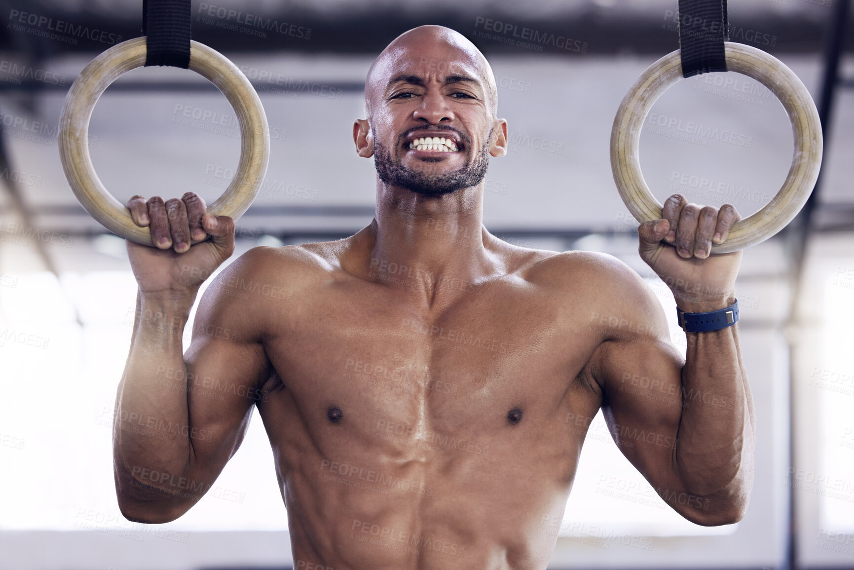 Buy stock photo Shot of a young man doing pull ups at a gym