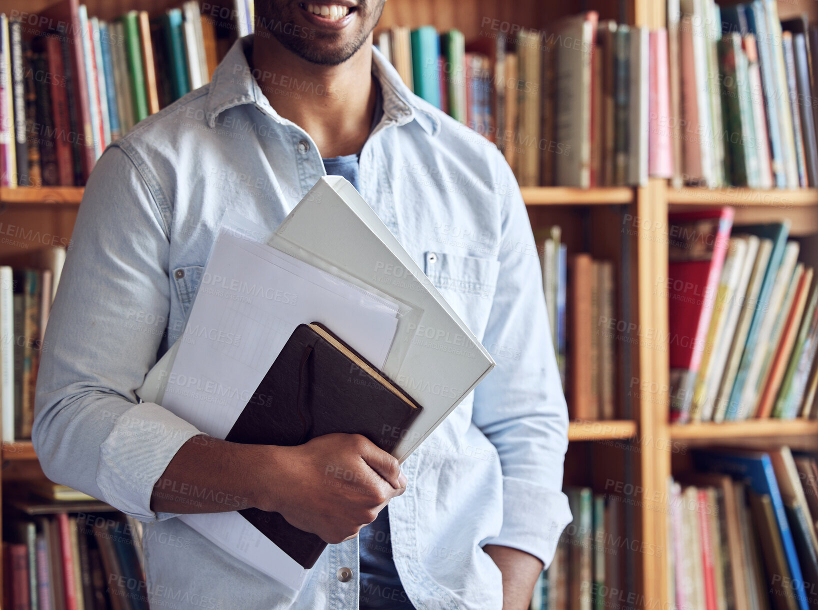 Buy stock photo Shot of an unrecognisable man studying in a library at university