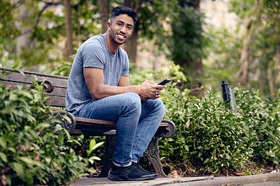 Buy stock photo Phone, man and student in park, smile and typing in app with connection to social media and chat. University, education and person in campus with mobile, texting and check for update in studying