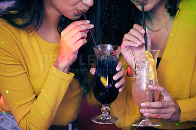 Buy stock photo Shot of two unrecognisable women having cocktails on a fun night out