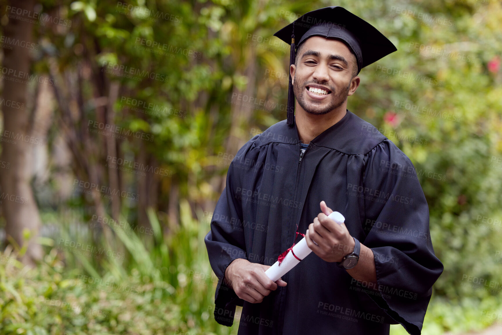 Buy stock photo Shot of a young man holding a certificate on graduation day