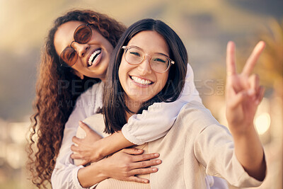 Buy stock photo Shot of a woman showing the peace sign while outside with her friend