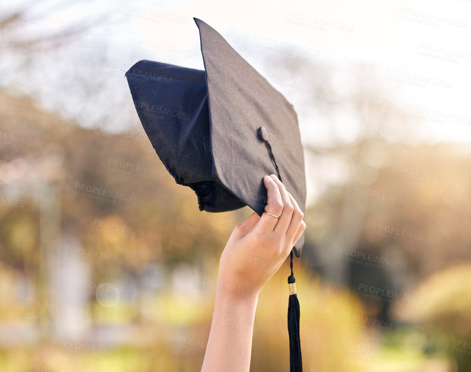Buy stock photo Person, nature and hand with graduation cap at university for education, success and academic growth. Student, future and celebration with hat at academy for scholarship, knowledge and achievement